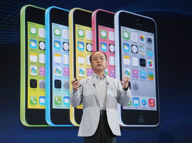 ソフトバンクの新商品発表会で登壇した孫正義社長。奥はスクリーンに映し出された米アップルの多機能携帯電話「iPhone 5c」＝2013年9月30日午後、東京都港区