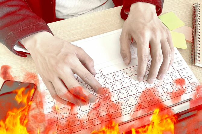 男性が使用しているノートパソコンから炎上しているイメージ