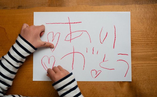 子どもが「ありがとう」と画用紙に書いている