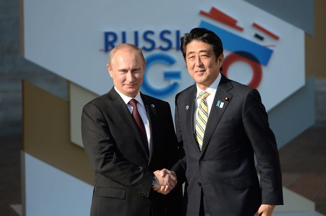 ロシアのプーチン大統領（左）と握手する安倍晋三首相（当時）