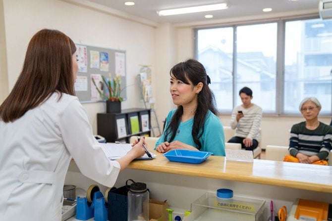 病院の受付で質問している女性