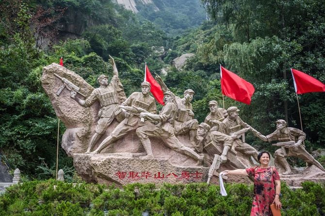 彫刻の前でポーズをとる中国人女性