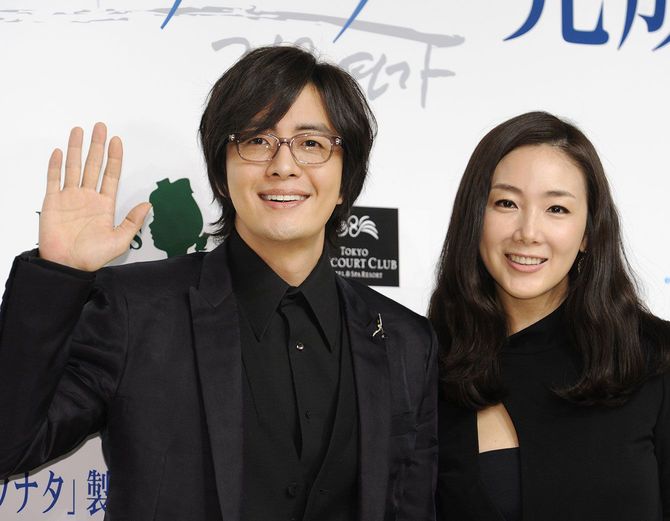 アニメ版「冬のソナタ」の完成披露会見で、手を振る韓国の俳優ペ・ヨンジュン（左）と笑顔を見せる女優のチェ・ジウ（右）＝2009年9月29日、東京