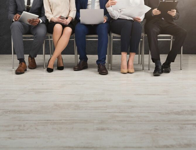 一列に椅子に座って働くビジネスマンのグループ