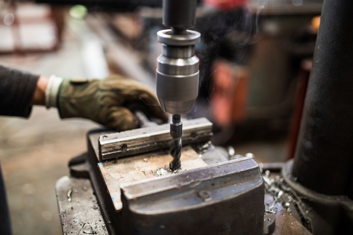 鉄鋼工場で製造用機械を使用する男性