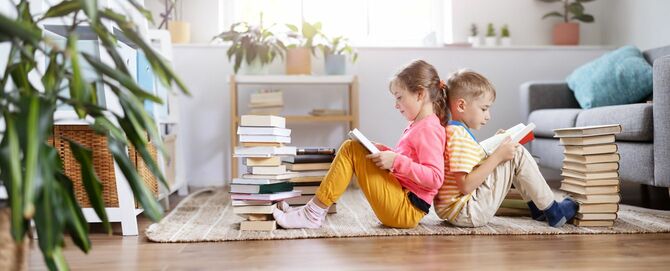 2人の子供が部屋の床に座って本を読む