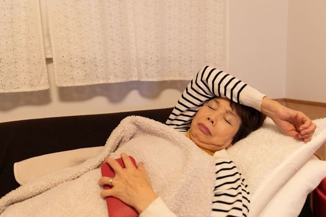 夜にソファで休むシニア女性