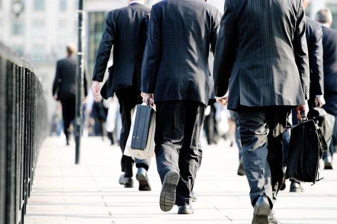 街を歩くスーツを着た人たち