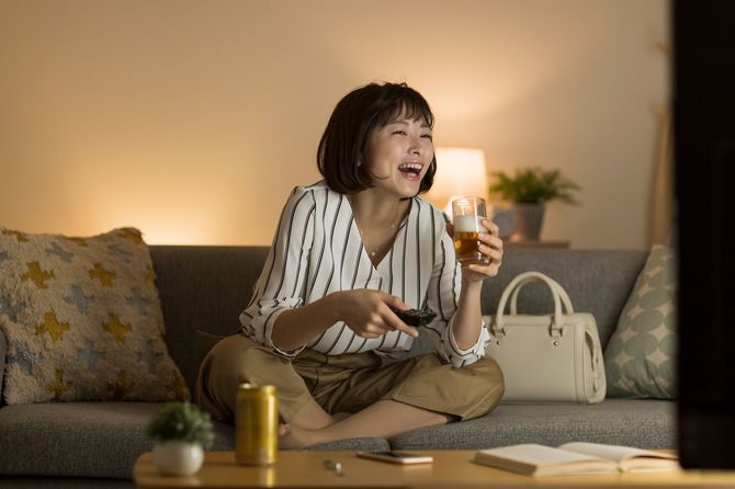 自宅でテレビを見て笑う人