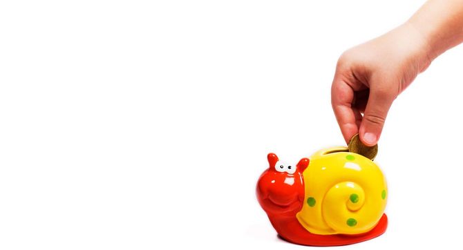 貯金箱にコインを入れる手