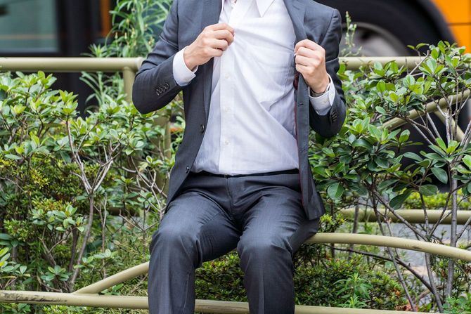 汗をかいているスーツを着た男性