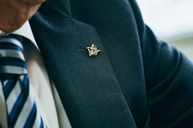 猪狩氏の胸元には「Renoir（ルノアール）」のバッジ