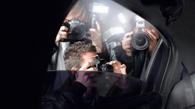 パパラッチが車に群がって写真を撮る
