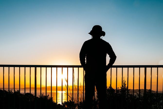 夕日を見つめる男性のシルエット