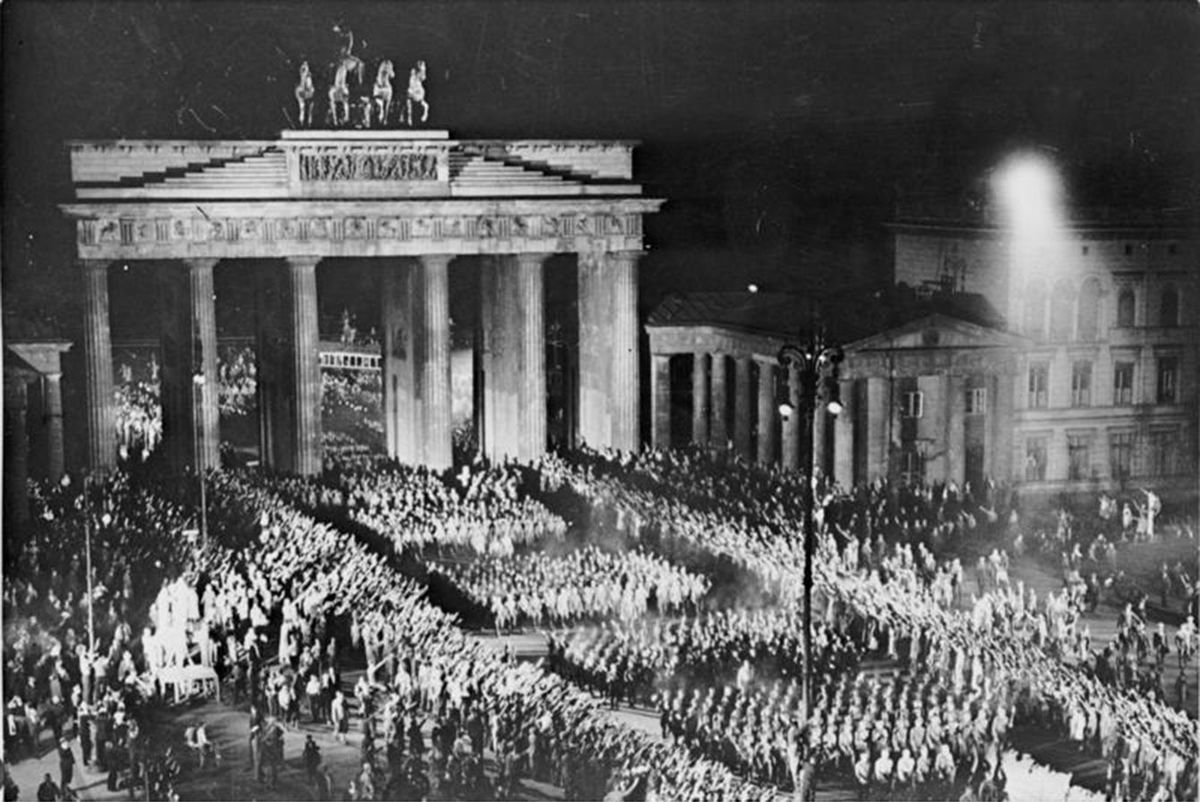 ヒトラーの首相就任を祝い、ブランデンブルク門を松明行進する突撃隊員たち（1933年1月30日）（写真＝CC-BY-SA 3.0／Wikimedia Commons）