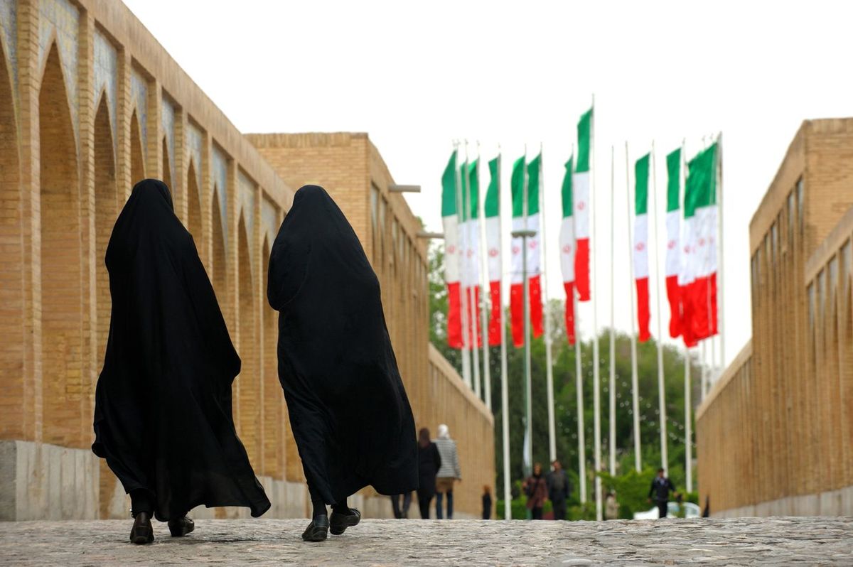 イランの国旗に向かって歩く人たち