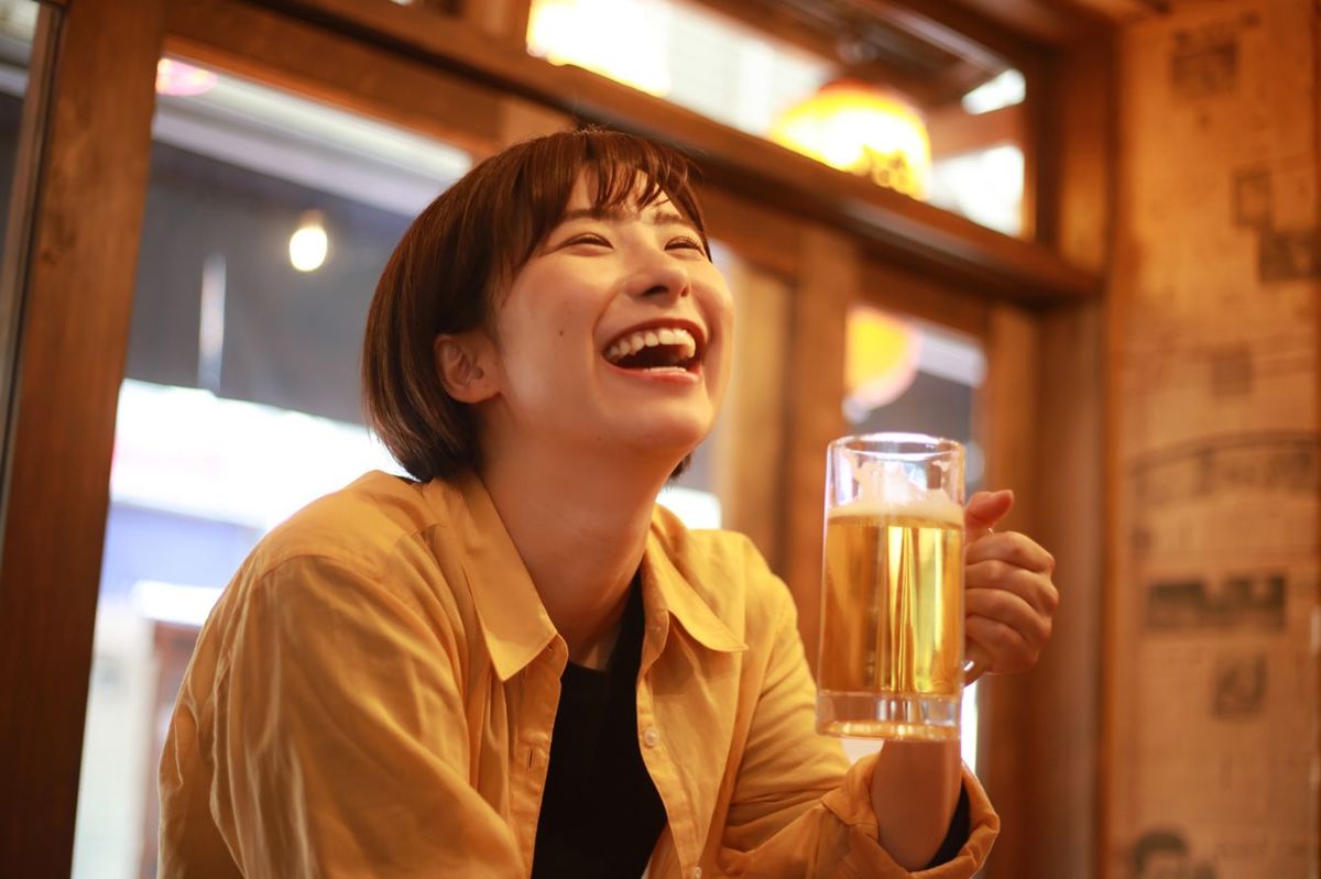 ビールを飲みながら笑う女性