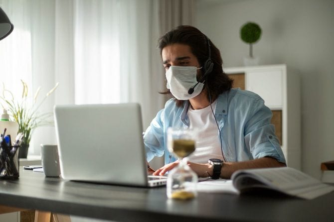 マスクを着けてパソコンに向かう男性