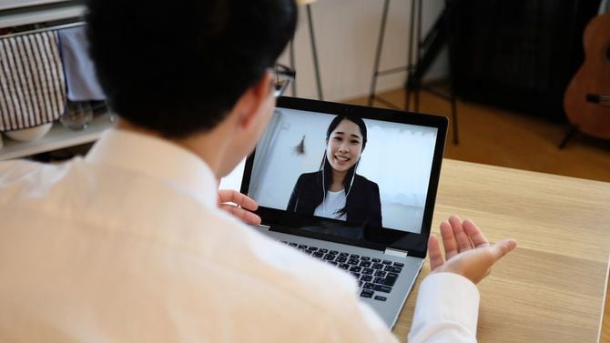 ウェブ会議で同僚と話すビジネスマン