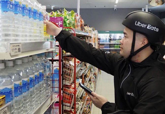 「まいばすけっと」で行われた、ウーバーイーツの配達員が注文された商品を選び、会計、配達までを担うサービスのデモンストレーション＝2024年6月26日午後、東京都内