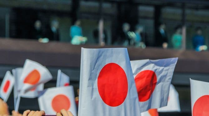 東京の正月初日に皇居前の広場にあるバルコニーの下の群衆。