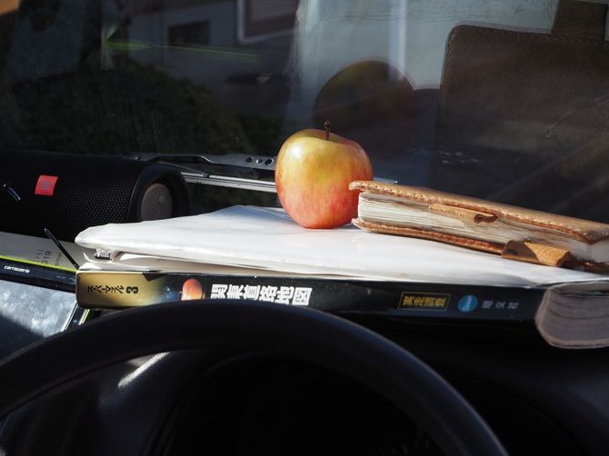 ダッシュボードに重なる地図や書類の上にあるリンゴ