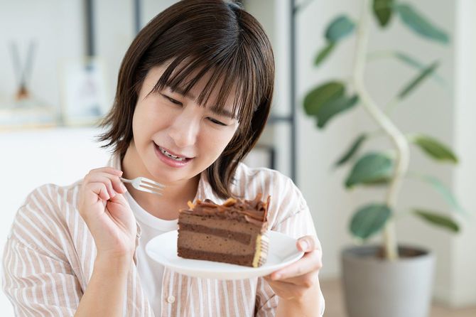 チョコレートケーキを食べている若い女性