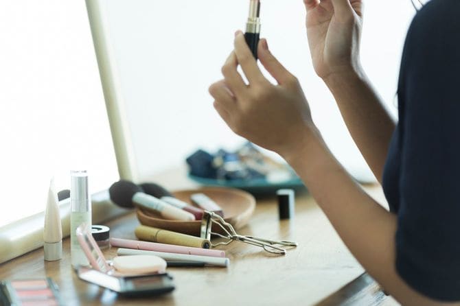 ドレッサーでメイクする女性