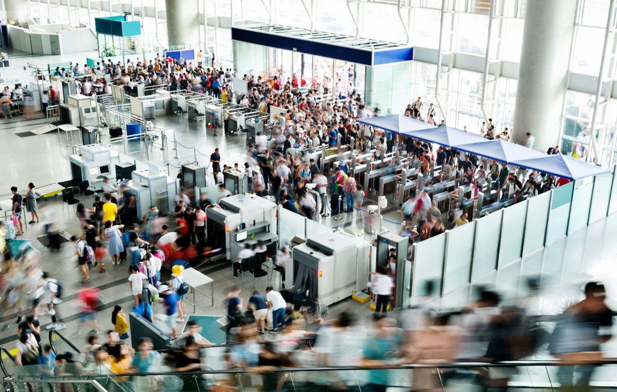 混雑した空港、手荷物検査場には行列ができている