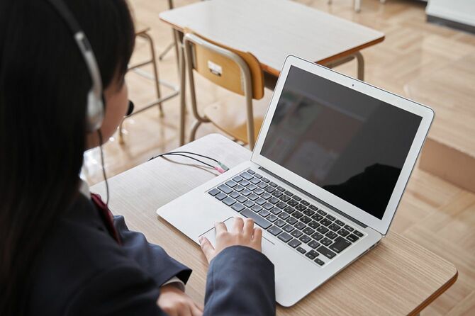 教室でパソコンを使って授業を受ける日本の中学生の女の子