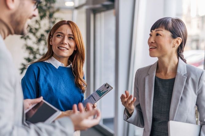 タブレットを使いながら仕事について話し合う同僚