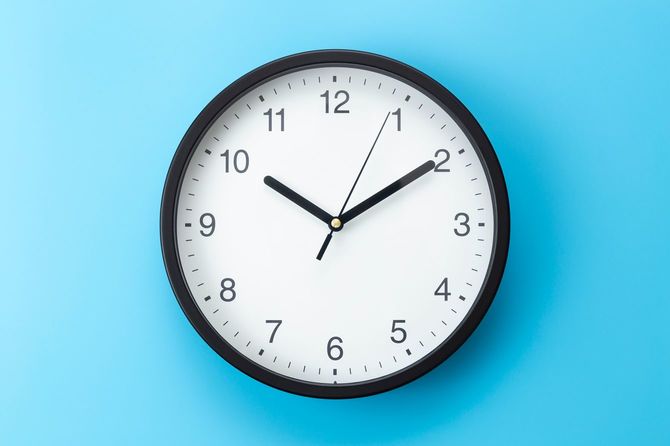 青い背景にぶら下がっている時計