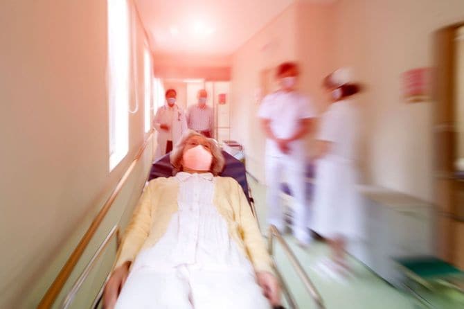 病院で担架に乗せられた高齢の女性