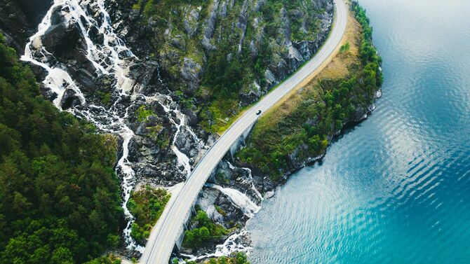 南ノルウェーのフィヨルド近くの絵のような道路を走る車のドローン撮影写真