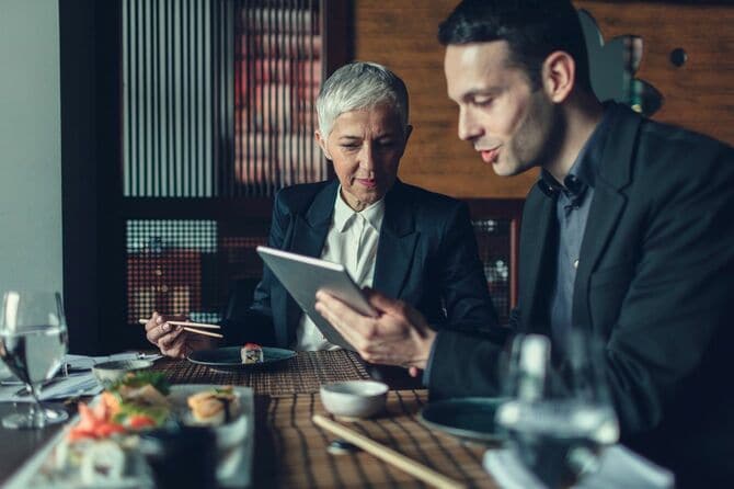 コーカソイド系のビジネスマンが寿司店でビジネスミーティング