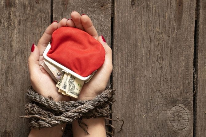 女性の縛られた手にアメリカドルが入った赤い財布