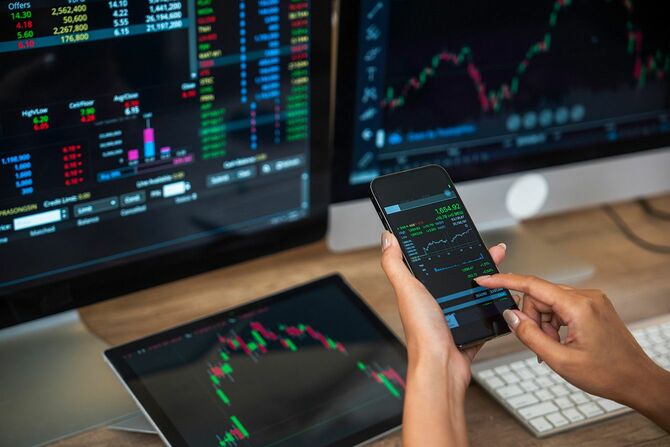 複数のモニタで株の取り引きをする人