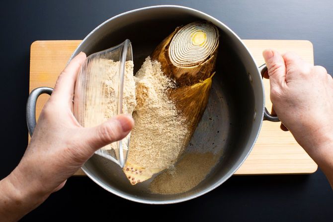 タケノコの灰汁抜きのため、鍋にぬかを投入している手元