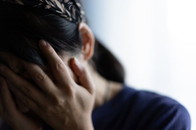 顔を手で覆って泣いている女性