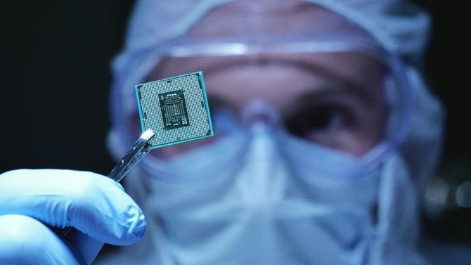 滅菌カバーオールを着用し、マイクロチップを持つ男性