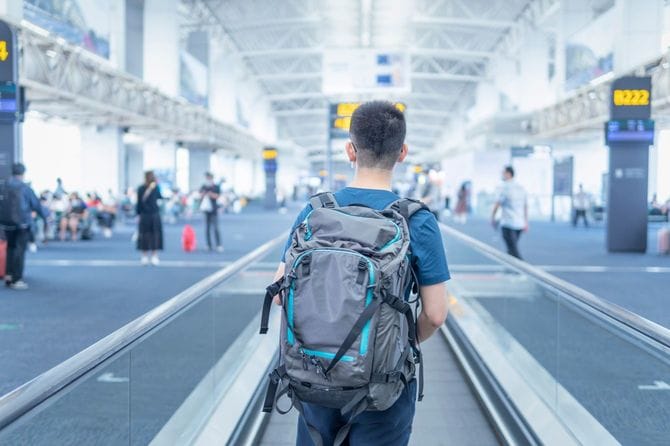 バックパックを背負って空港を歩く男性