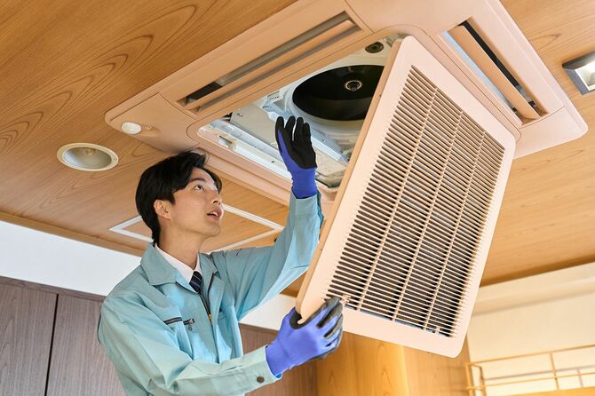 業務用エアコンの調整をする作業員