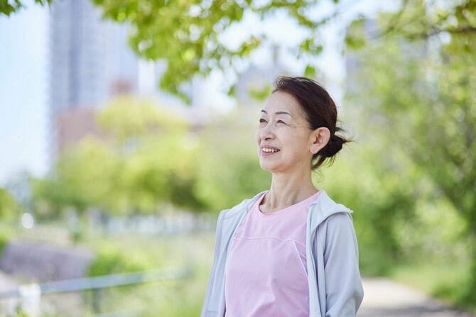 春の新緑の中でランニングを楽しむスポーツウェアを着た年配の女性