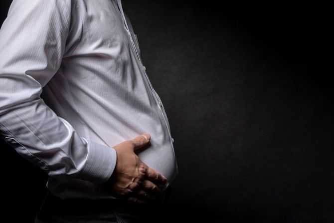 太った腹を気にする男性