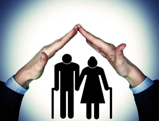 高齢者のシルエットイラストに家の屋根のように被せる手