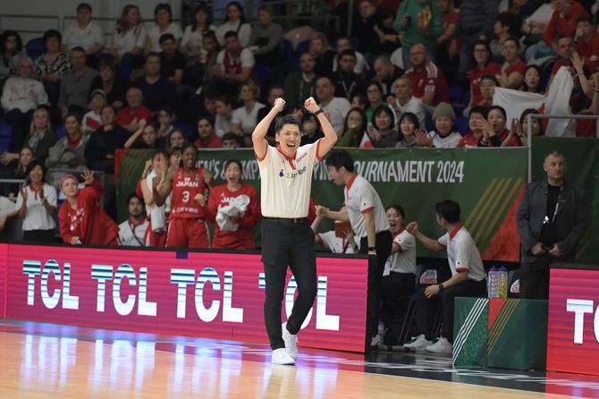 コート内でガッツポーズをする恩塚HC