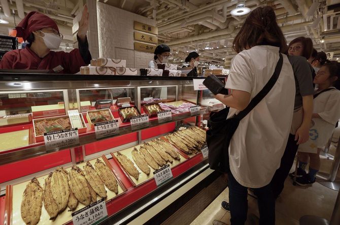 土用の丑の日を迎え、阪神梅田本店でウナギのかば焼きや弁当を買い求める人たち