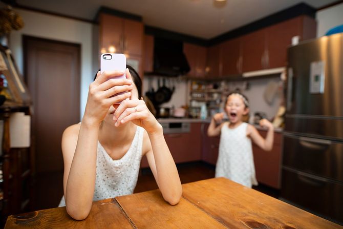 スマートフォンに夢中の母親