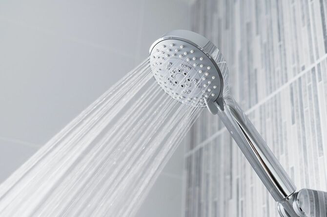 モダンなバスルームでシャワーヘッドと蛇口から流れる水