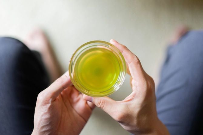 ガラスコップに入った緑茶を手にしている男性